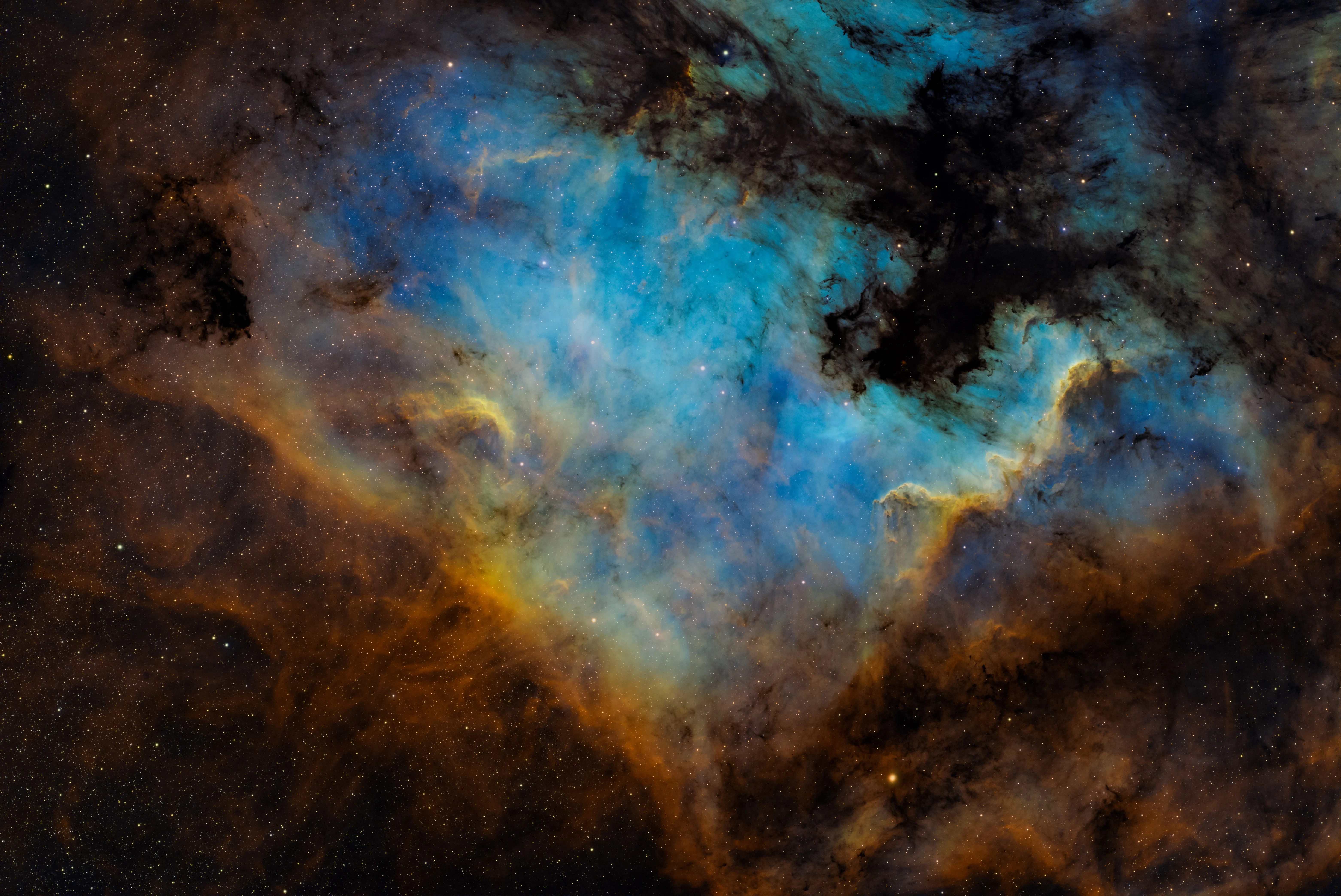 The North America Nebula in warm red hydrogen emission divided by dark dust